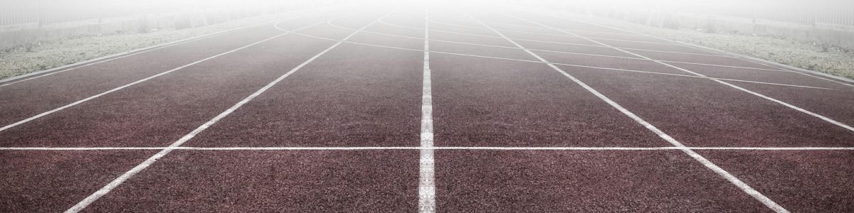 A foggy track field with visible lane numbers and white lines.